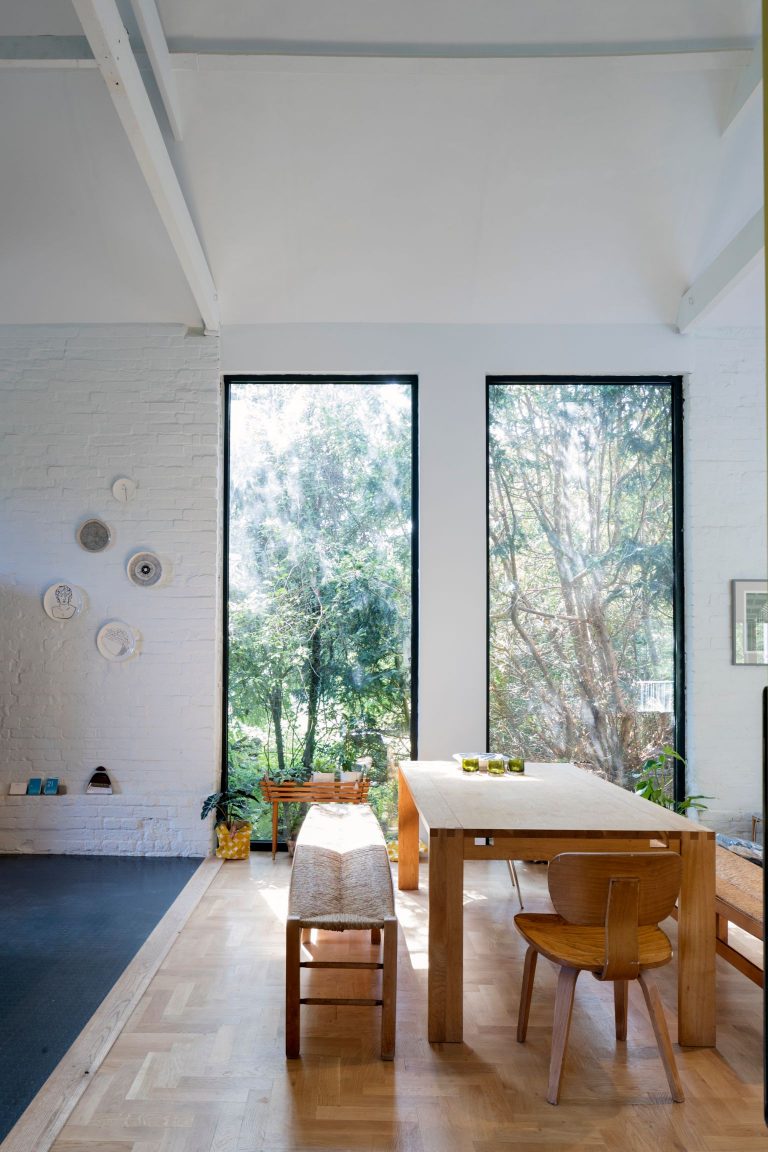 Five Acre Barn, Suffolk - Dining room with large windows looking out to woodlands and garden