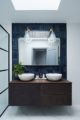 Dark navy blue bathroom tiles with large wooden sideboard