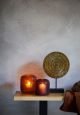 Dark red candle holders on a wooden shelf.