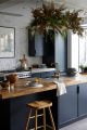 Dark grey kitchen cabinets with repurposed wooden worktops, Loxwood Oak Bar Stool and faux foilage.