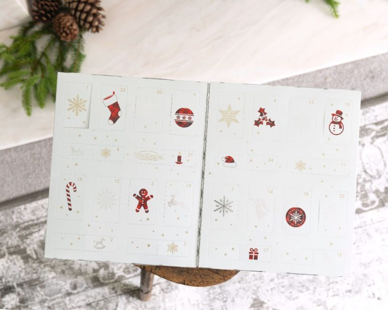 White advent calendar with illustrations filled with shortbread by Walker's