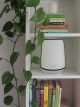 Netgear Orbi on shelf with books and plants