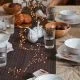 Autumnal dinner table with lights and pumpkins