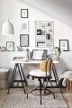 Monochrome modern office setup with white desk, soft cushion and black framed pictures on the wall.