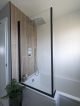Faux wood tiled bathroom with black framed shower screen.