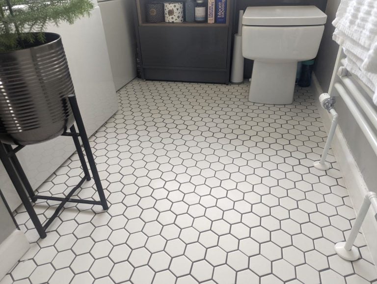 White hexagon floor tiles with grey grouting in a bathroom.
