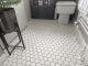 White hexagon floor tiles with grey grouting in a bathroom.