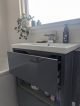 Grey bathroom vanity with pull out drawer.