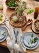 Grey reactive dinner plate set on a wooden table filled with small summer accents.