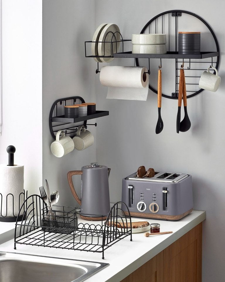 Grey toaster and kettle with wood accents on work top, featuring black shelves on the wall.