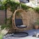 Modern brown and black hanging egg chair with grey cushions.