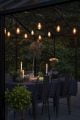 Outdoor dining with warm white hanging festoon lights.