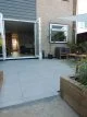 Patio with large grey patio tiles and dark grey grouting.