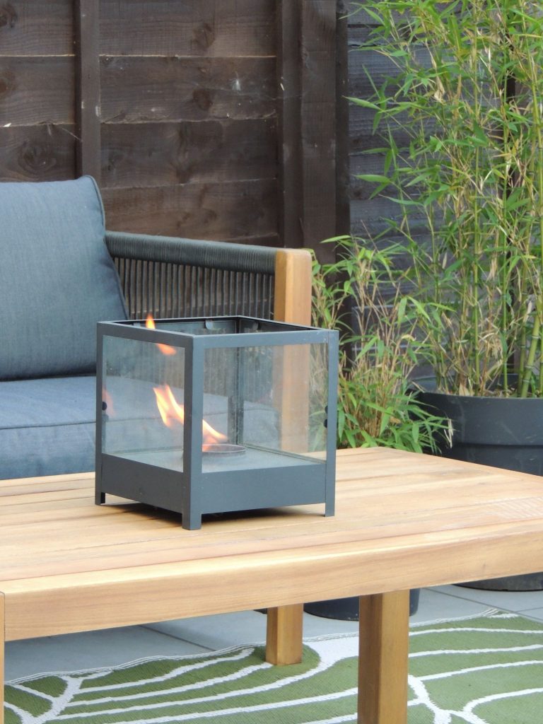 Wooden coffee table with a black outdoor fire pit.