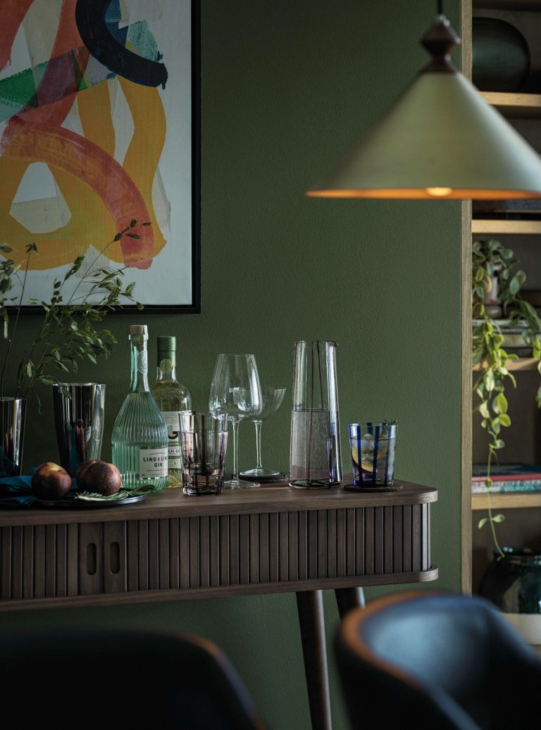 Mid-Century inspired drinks sideboard with sliding doors and glasses placed on top from John Lewis.