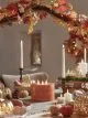 Autumn party dinner table with an orange LED candle, brass light up pumpkins and knitted pumpkins from Lights4Fun.