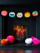 Black fireplace with colourful pumpkin halloween bunting and colourful paper honeycomb pumpkin decorations.