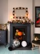Black fireplace decorated with autumnal decorations, pumpkins and a large disco ball.