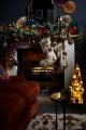 Dark blue walls surrounding a fireplace with Christmas stockings and a large green garland.