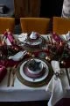 Christmas dinner table with white cloth and a red table runner.