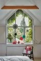 Looking out a window with round paper decorations and Christmas presents.