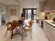 Modern kitchen with wood-effect cupboards and mid-century furniture.