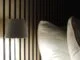 Battery-powered white metal table lamp on bedside table.