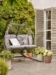 Hanging two-seater outdoor egg chair with grey rattan and cushions by Dobbies.