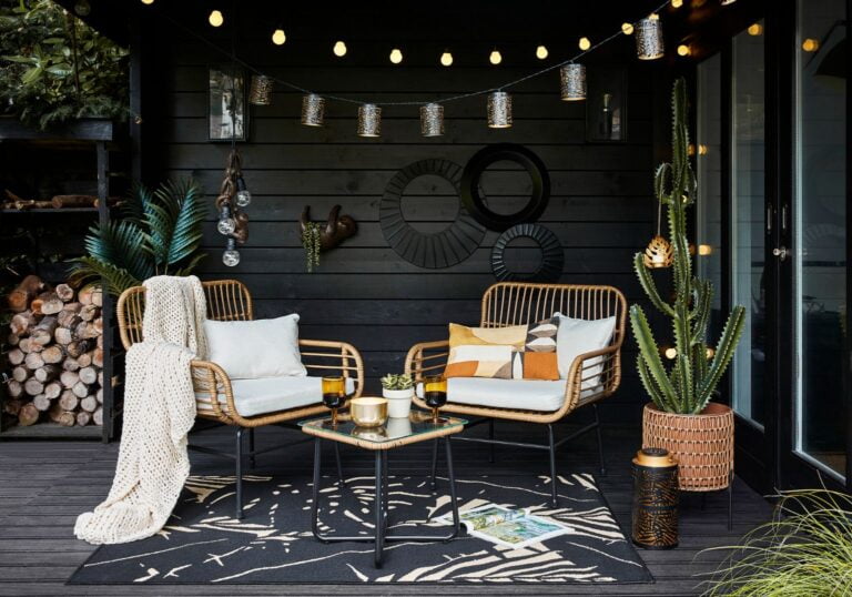 Rattan armchair bistro set with black legs and a glass rattan coffee table, by Dunelm.
