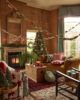 Warm cosy fireplace, next to a Christmas tree. Sofas filled with cushions and blankets.