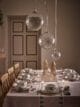 Simple white Christmas dining table with large hanging snowflake baubles.