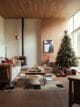 This living room is all set for Christmas with a crackling fireplace, a beautifully decorated tree, and a pile of presents.